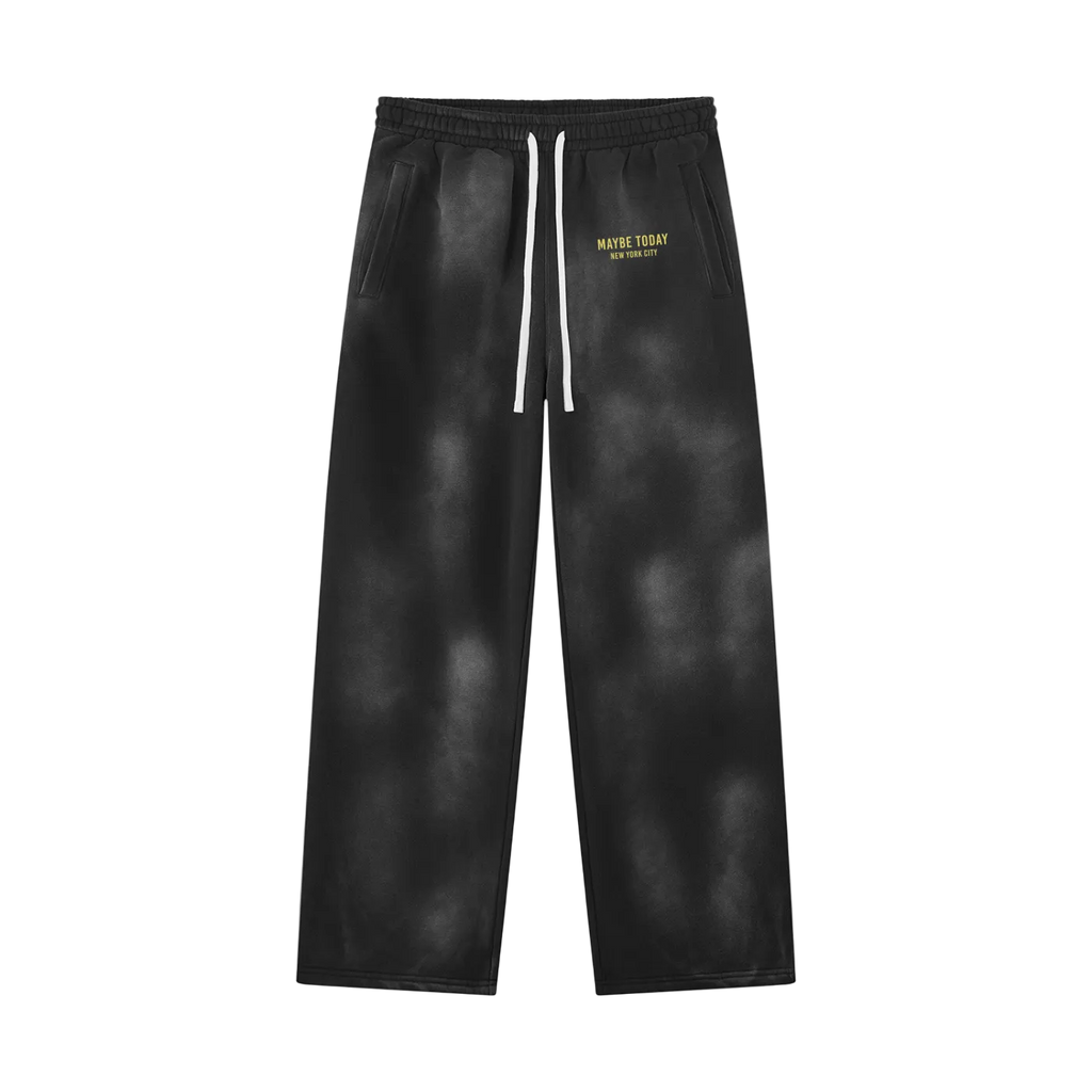Black tie-dye sweatpants with a white drawstring and yellow 'MAYBE TODAY' text on the left hip, shown flat on a white background.